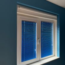 Blauwe aluminium jaloezieën in een donkerblauwe kamer.