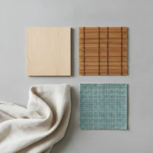 Stalen van verschillende duurzame materialen voor raamdecoratie, waaronder hout, bamboe en gerecyclede stof, overzichtelijk naast elkaar gelegd op een lichte ondergrond.
