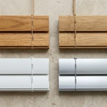 Stalen van de vier beschikbare materialen voor jaloezieën: hout, bamboe, PVC en aluminium, overzichtelijk naast elkaar gepresenteerd.
